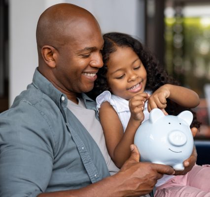 Father and daughter saving money in a piggybank